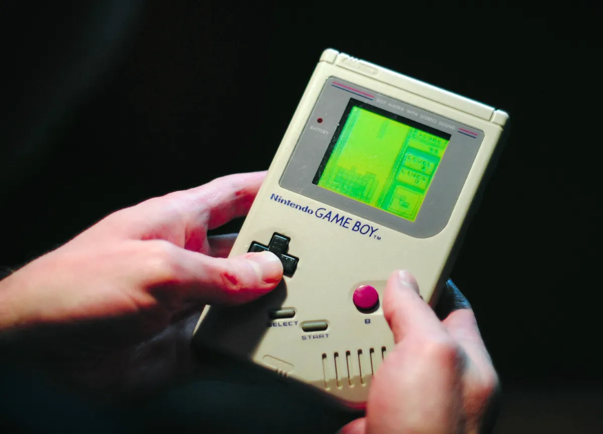 Person holding Nintendo Gameboy