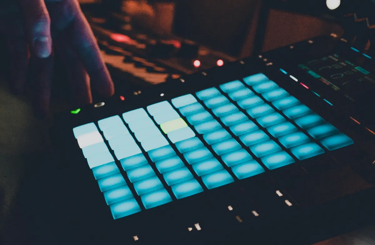 Person in a dark room playing a sampler